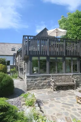 a large house with a deck and a bench at Welsh Hideaways in Pentre-briwnant