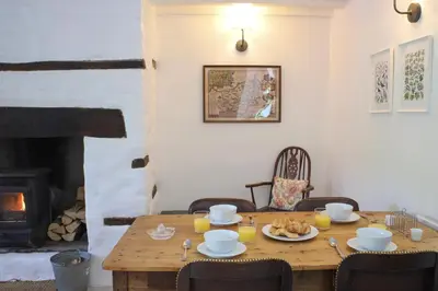 a wooden table with food on it in a room with a fireplace at Abbey Cottages- Red Kite Lodge in Talley
