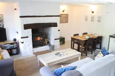 a living room with a fireplace and a table at Abbey Cottages- Red Kite Lodge in Talley