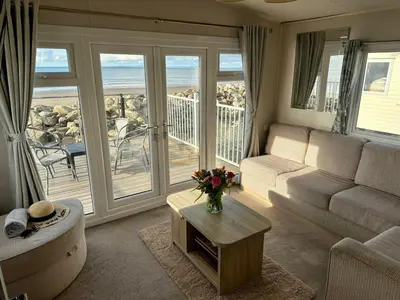 a living room with a couch and a table at Dolphin View in Llanddwywe