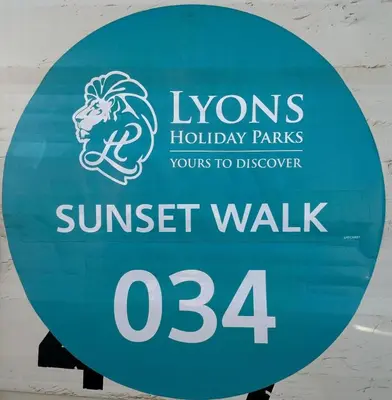 a sign for the hyns holiday parks sunset walk at Dolphin View in Llanddwywe