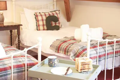 a room with a bed and a table with a tray at Abbey Cottages- Heron House in Talley