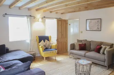 a living room with a couch and a chair at Abbey Cottages- Heron House in Talley