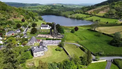 an aerial view of a house and a lake at Abbey Cottages- Heron House in Talley