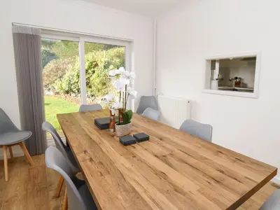 a dining room with a wooden table and chairs at Ty Melyn in Aberystwyth