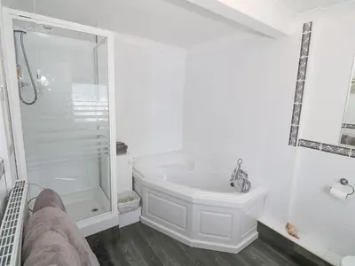 a white bathroom with a tub and a shower at Goetra in Harlech