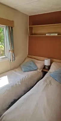 two beds sitting next to each other in a room at Brynowen Holiday Park Borth in Borth