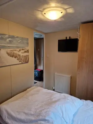 a bedroom with a bed and a flat screen tv at Brynowen Holiday Park Borth in Borth