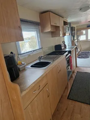 a small kitchen with a sink and a stove at Brynowen Holiday Park Borth in Borth