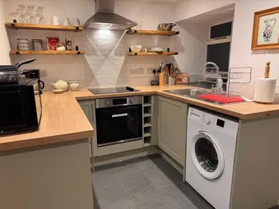 a kitchen with a sink and a washing machine at Henllys Cottage in Corwen