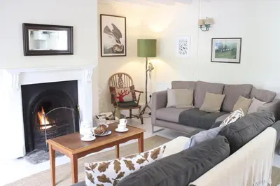 a living room with a couch and a fireplace at Abbey Cottages - Buzzards Watch in Talley