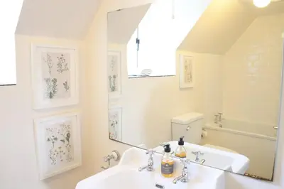a bathroom with a white sink and a mirror at Abbey Cottages - Buzzards Watch in Talley