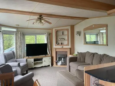 a living room with a couch and a flat screen tv at Family 3 Bedroom Caravan at Clarach Bay in Aberystwyth