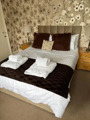 a bedroom with a bed with towels on it at Hazeldene Guest House in Aberaeron