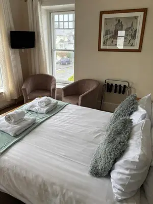 a bed with towels and a stuffed animal on it at Hazeldene Guest House in Aberaeron