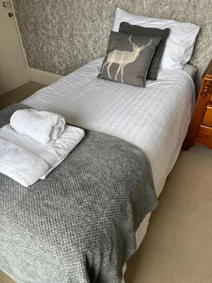 a bed with two pillows and towels on it at Hazeldene Guest House in Aberaeron
