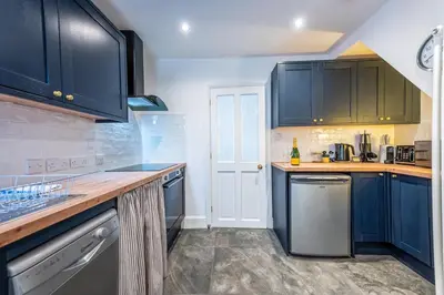 a kitchen with blue cabinets and a counter top at Quaint home with log burner in peaceful cul-de-sac in Shrewsbury