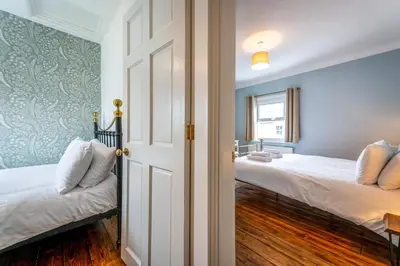 a bedroom with two beds and a door with a window at Quaint home with log burner in peaceful cul-de-sac in Shrewsbury