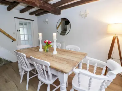 a dining room with a wooden table and white chairs at The Old Shop in Builth Wells