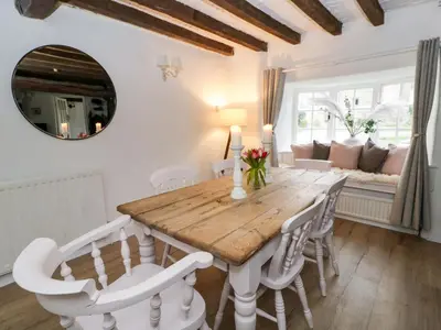 a dining room with a wooden table and white chairs at The Old Shop in Builth Wells