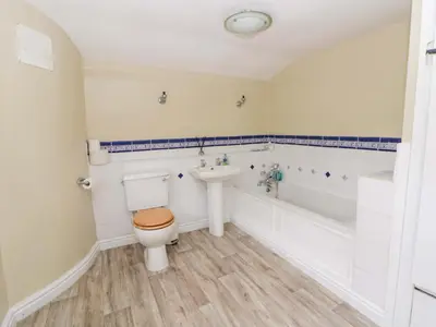 a bathroom with a toilet and a tub and a sink at The Old Shop in Builth Wells