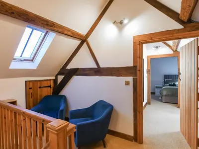 a room with two blue chairs in a attic at The Byre At Woodgate Farm in Church Stretton