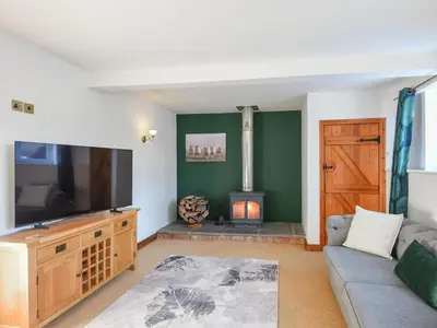a living room with a couch and a fireplace at The Byre At Woodgate Farm in Church Stretton