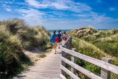 people walking down a wooden path to the beach at Melin-Bennar in Dyffryn