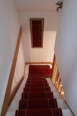 a staircase with a red carpet and a window at Holiday Home Haus in Crickadarn mit Parkplatz und Bergblick by Interhome in Crickadarn