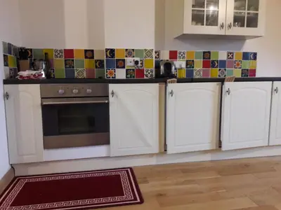 a kitchen with white cabinets and a stove at Holiday Home Haus in Crickadarn mit Parkplatz und Bergblick by Interhome in Crickadarn