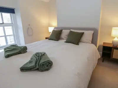 a bedroom with a large bed with green towels on it at Cariad Cottage in Hereford