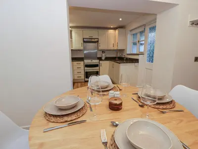 a dining room table with plates and wine glasses at Cariad Cottage in Hereford