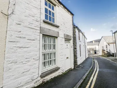 a white building with a door on the side of a street at Cariad Cottage in Hereford