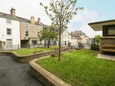 a yard with a tree in the middle of houses at Cariad Cottage in Hereford