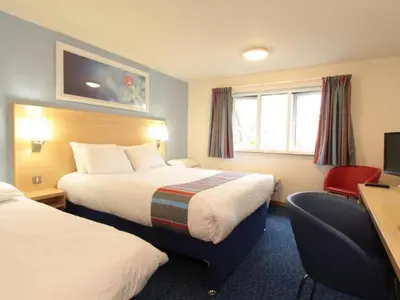 a hotel room with two beds and a desk at Travelodge Ludlow in Ludlow