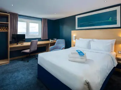 a hotel room with a large bed and a desk at Travelodge Oswestry in Oswestry