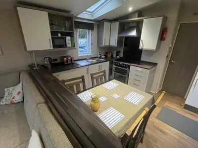 a small kitchen with a table and a couch at Sea and Bay Viev Luxury Lodge in Clarach bay in Aberystwyth