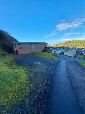 an empty road next to a building in a field at Sea and Bay Viev Luxury Lodge in Clarach bay in Aberystwyth