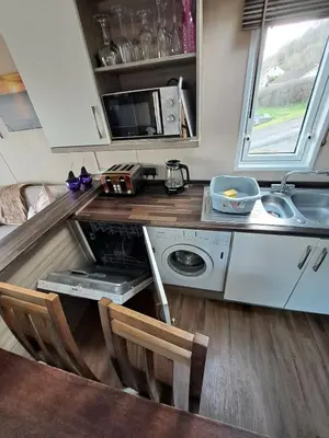 a small kitchen with a sink and a microwave at Sea and Bay Viev Luxury Lodge in Clarach bay in Aberystwyth