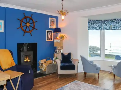 a living room with a blue wall at Brig Y Don in Borth