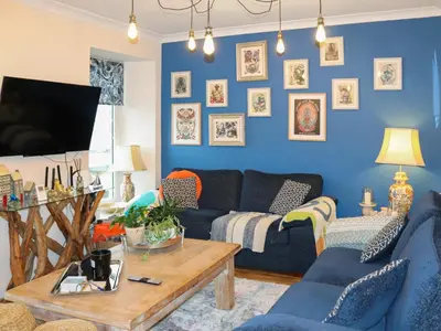 a living room with blue walls and a blue couch at Brig Y Don in Borth