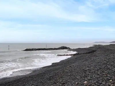 a pebble beach with a rocky shoreline at Brig Y Don in Borth