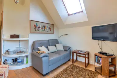 a living room with a blue couch and a flat screen tv at Finest Retreats - Canal Central in Ball