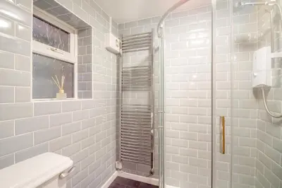 a white tiled bathroom with a glass shower at 2 Bed in Trawsfynydd oc-t34148 in Trawsfynydd