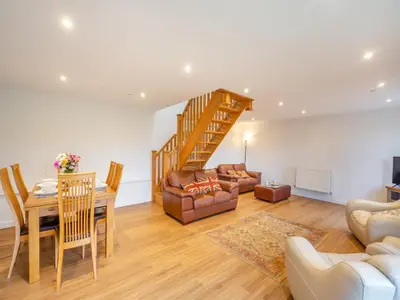 a living room with a staircase and a dining room at Arenig View - Uk51068 in Frongoch