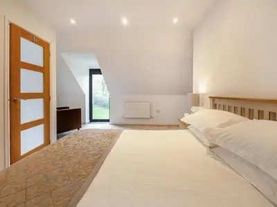 a white bedroom with a bed and a window at The Aran - Uk51067 in Frongoch