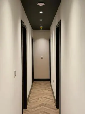 an empty corridor with white walls and wooden floors at The Resting Place in Aberystwyth