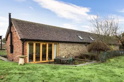 a small brick house with a table in a yard at Orchard Farm in Ludlow