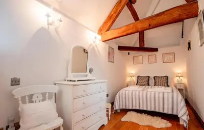 a bedroom with a bed and a dresser and a mirror at 5 bedroom Barn, Ludlow in Caynham