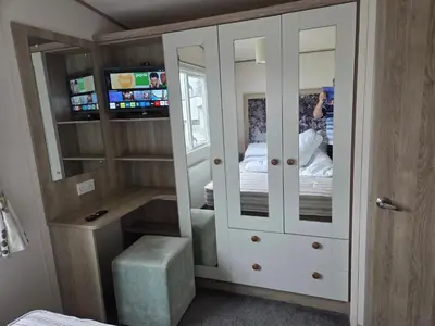 a person taking a picture of a bedroom at Privately owned Pet friendly caravan in Llanddwywe